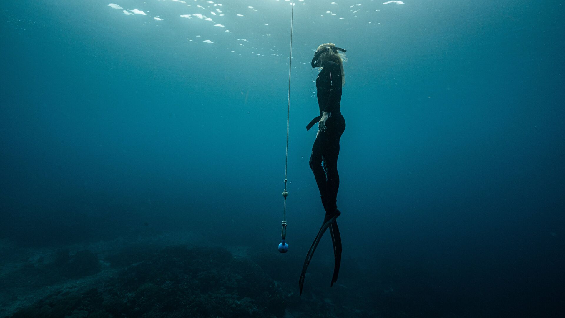Meisje freedivet met een touw in de oceaan van Indonesië