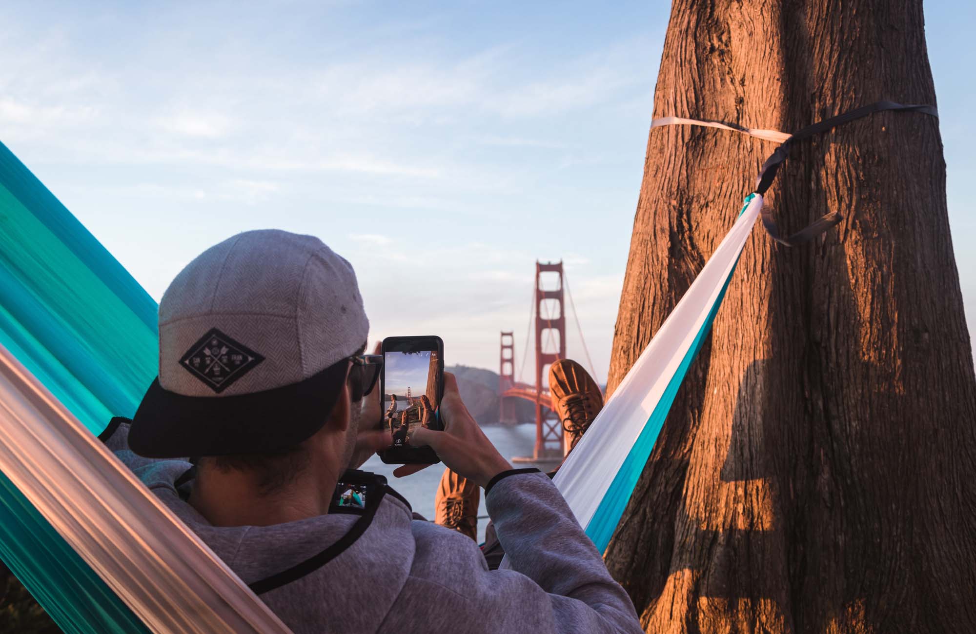 ung fyr slapper af i en hængekøje foran golden gate bridge på hans studietur til San Francisco
