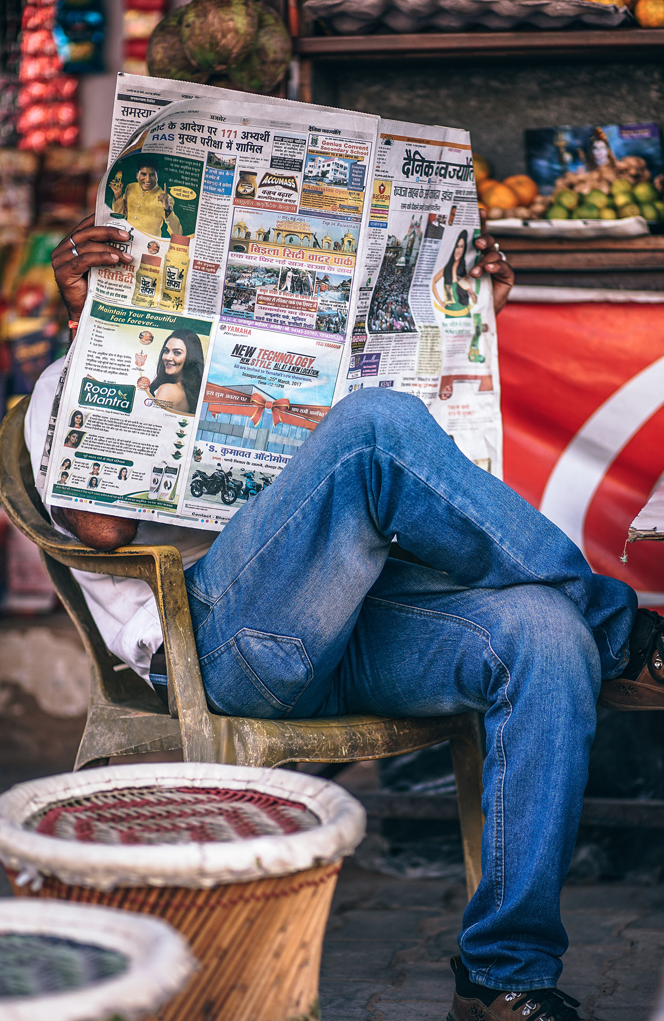 en mand læser en avis med benene over kors