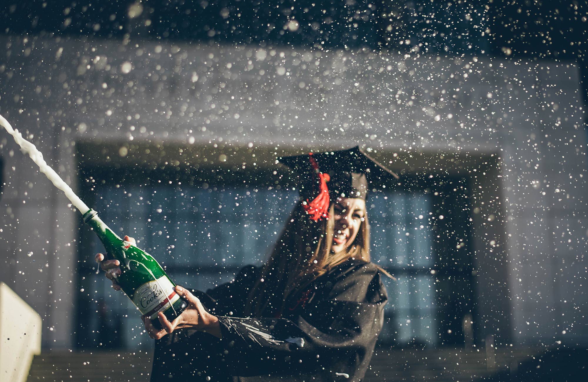 Færdiguddannet kandidat sprøjter med champagne