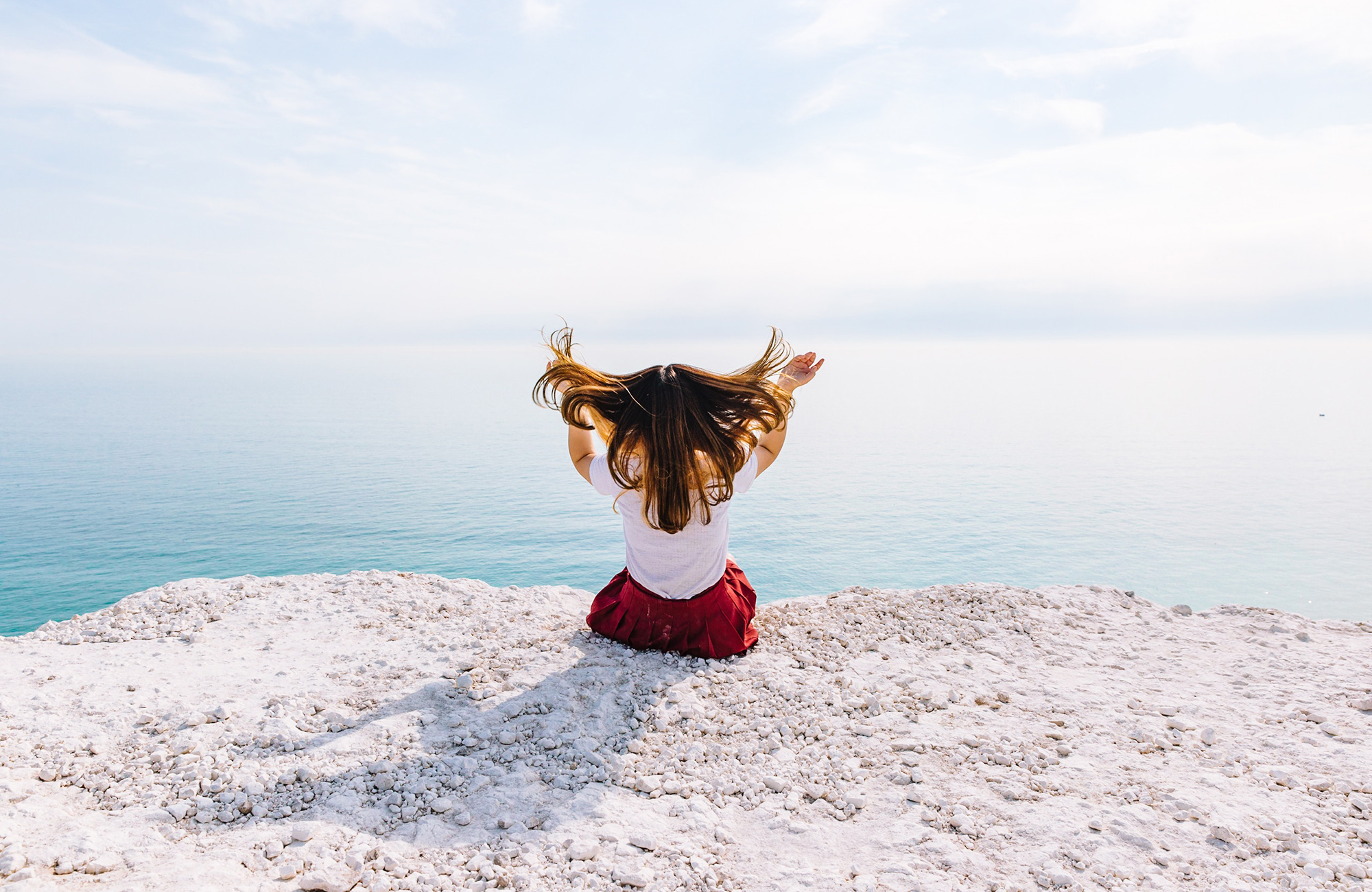 pige sidder på en klippe på sydkysten i england