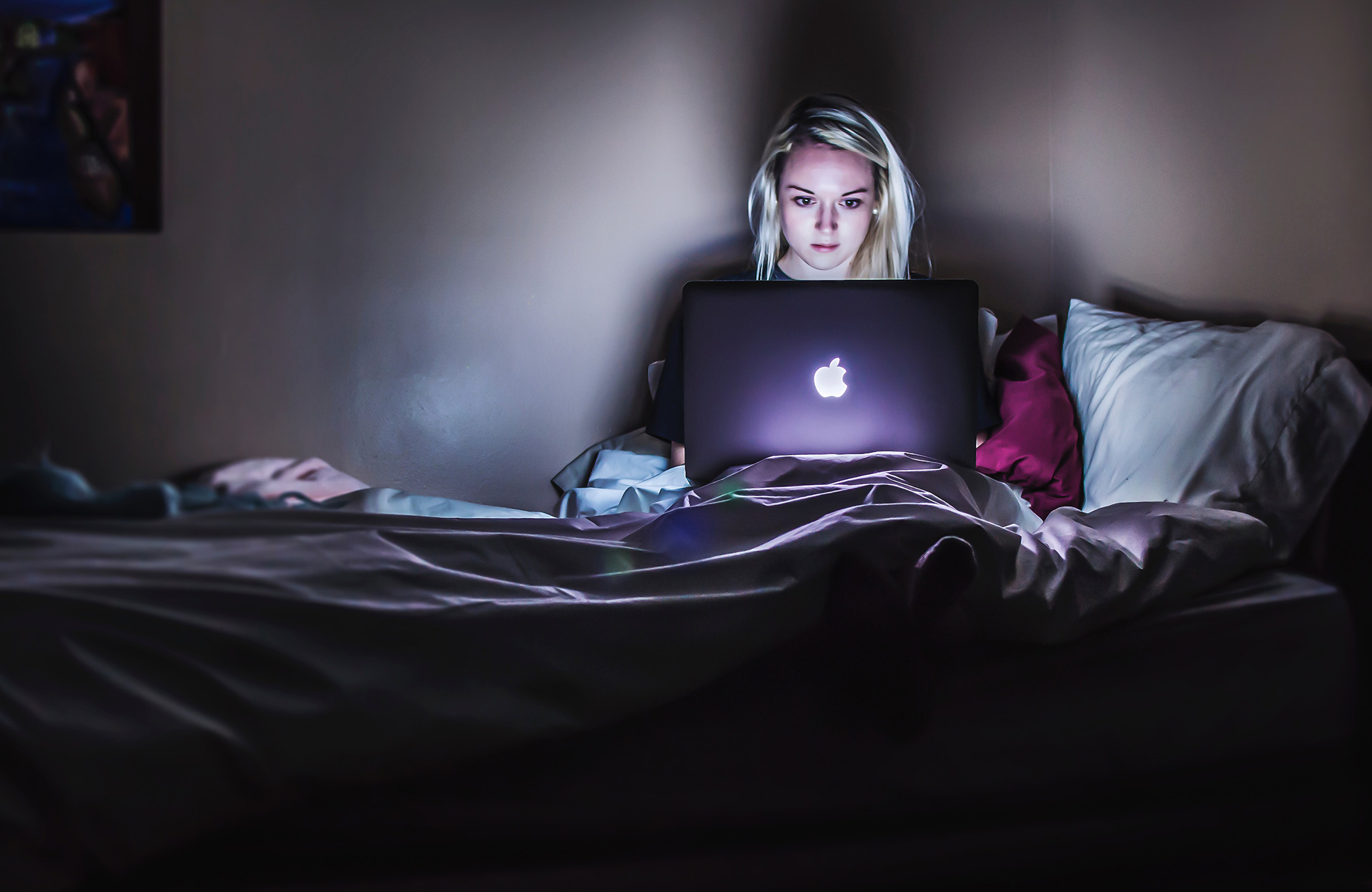 en pige søger jobs fra sin seng efter at have læst i udlandet