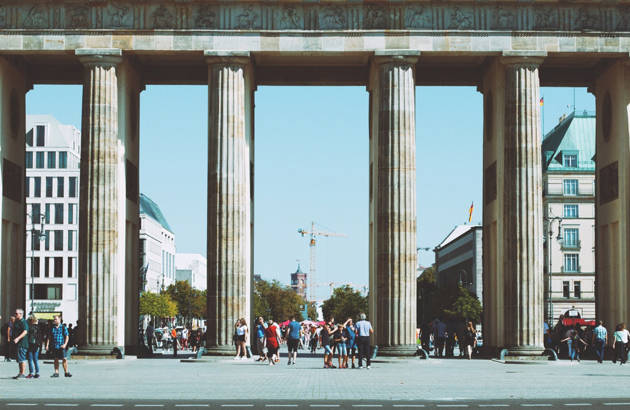 en masse mennesker på grupperejse til berlin foran brandenburger tor på en sommerdag