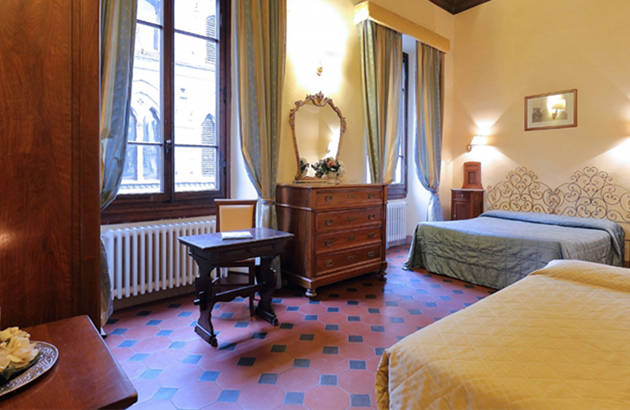 et værelse på Hotel Cimabue i firenze med gamle møbler