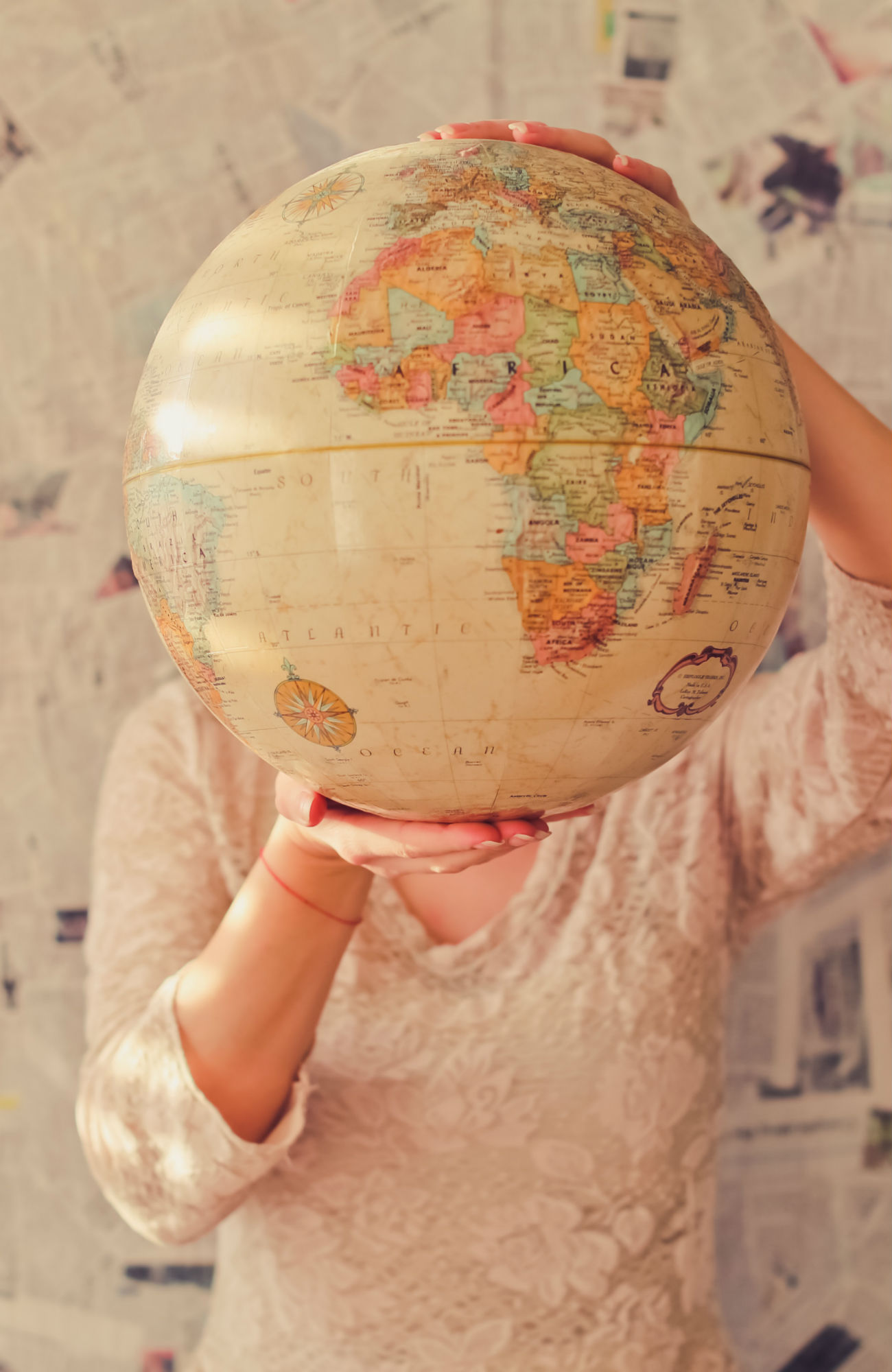 kvindelig studerende holder en globus op foran ansigtet