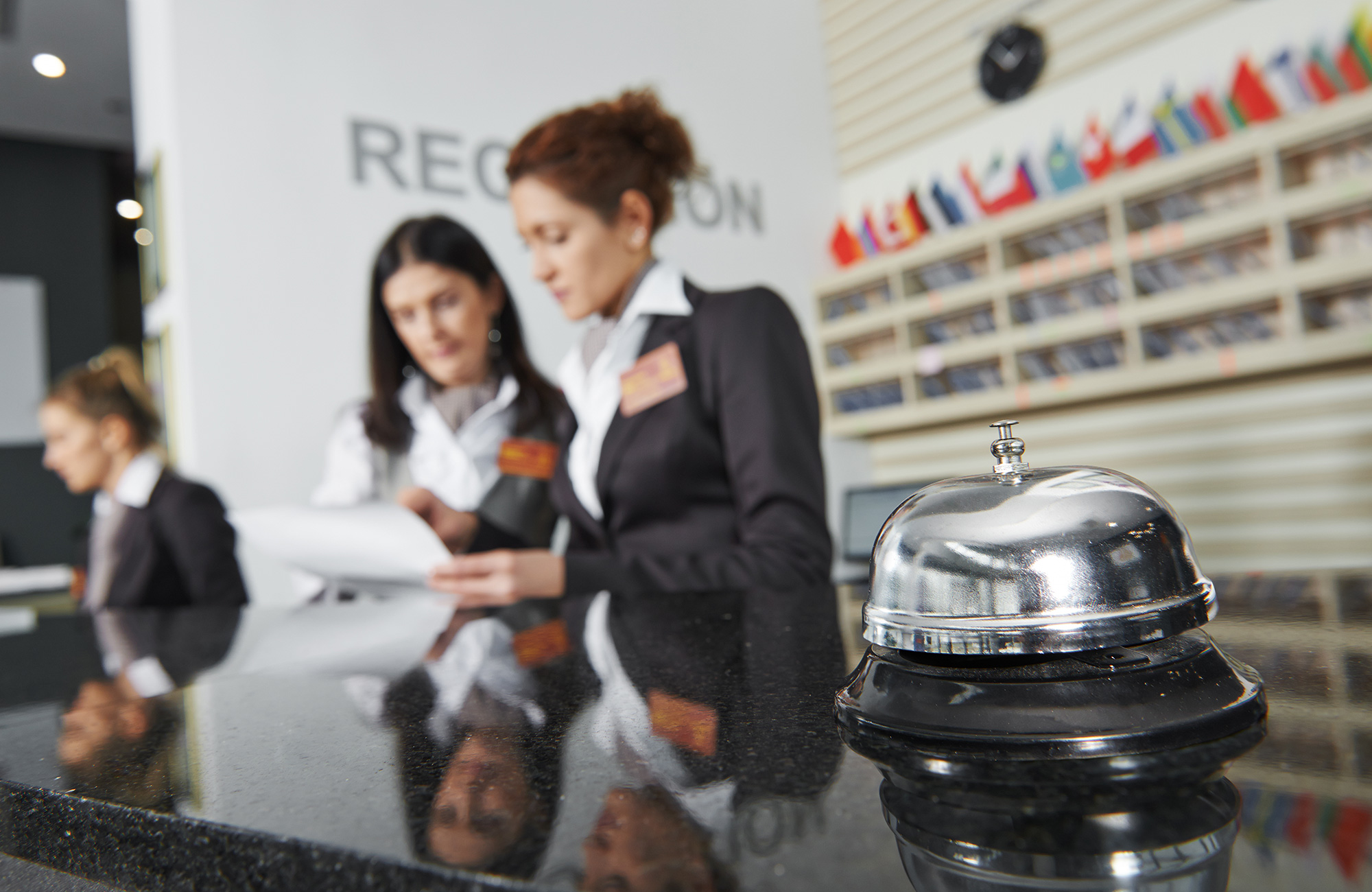 tre kvindelige studerende i hotel management øver sig i receptionist arbejdet