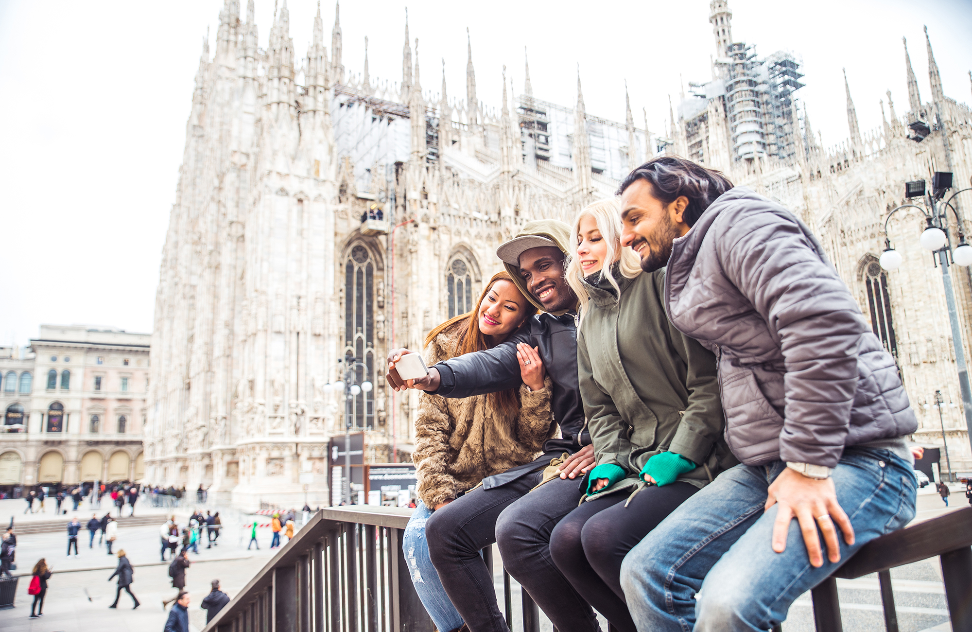 fire unge på studietur i milano og tager et selfie foran en smuk kirke