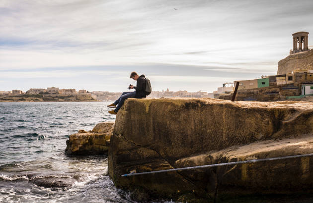 en mandlig turist på studietur på malta ved havet