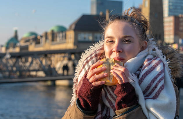 en ung kvinde smager maden på en studietur til Hamborg