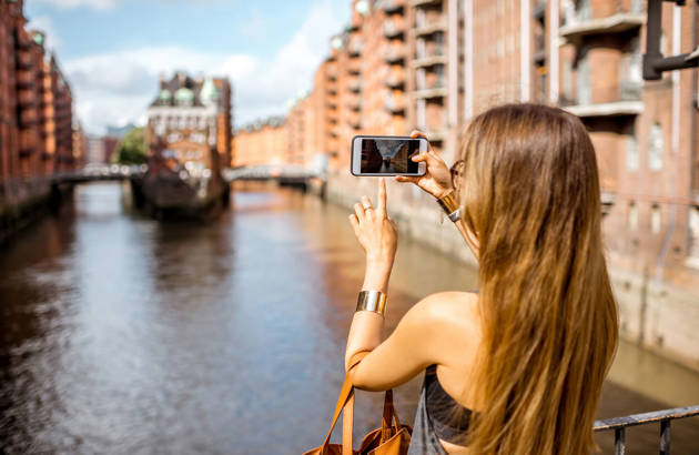 ung kvindelig studerende tager billede af kanalen på studieturen til Hamborg