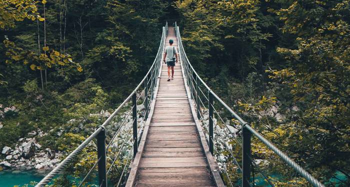 en mand går på den ikoniske bro i kobarid i det vestlige balkan