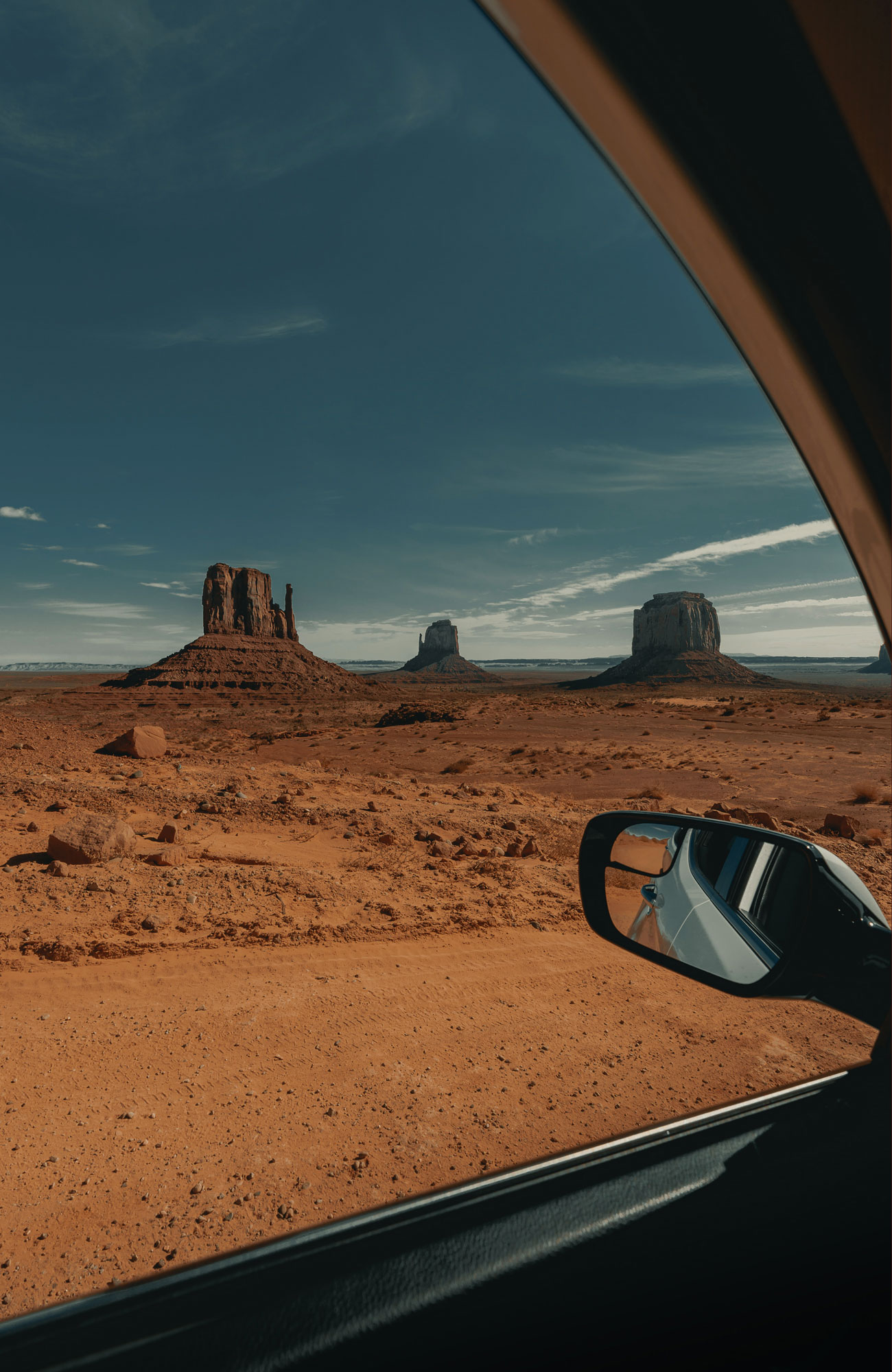 View of desert and rocks taken through a car window