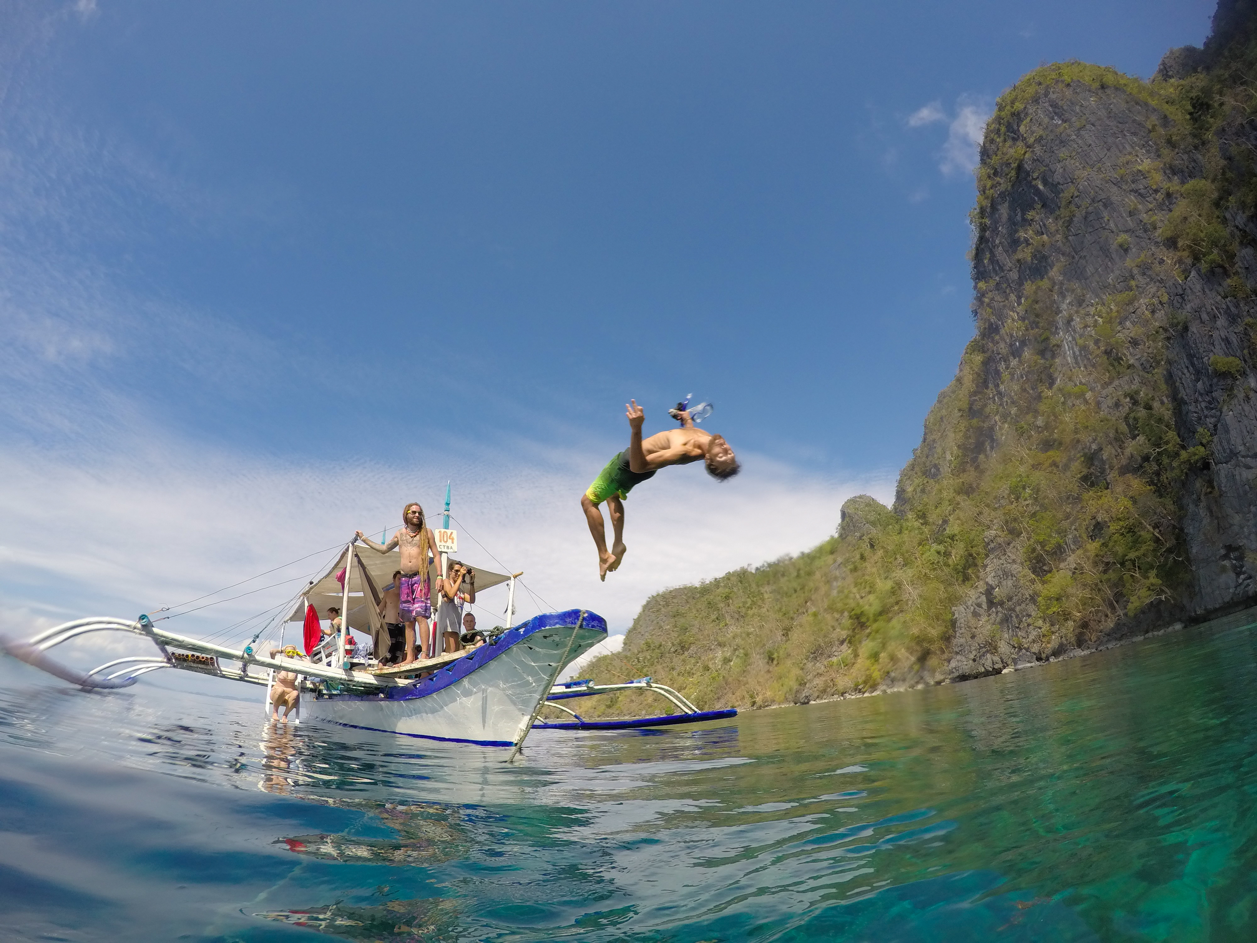 Billede af en mand, der hopper fra en båd i Filippinerne - KILROY