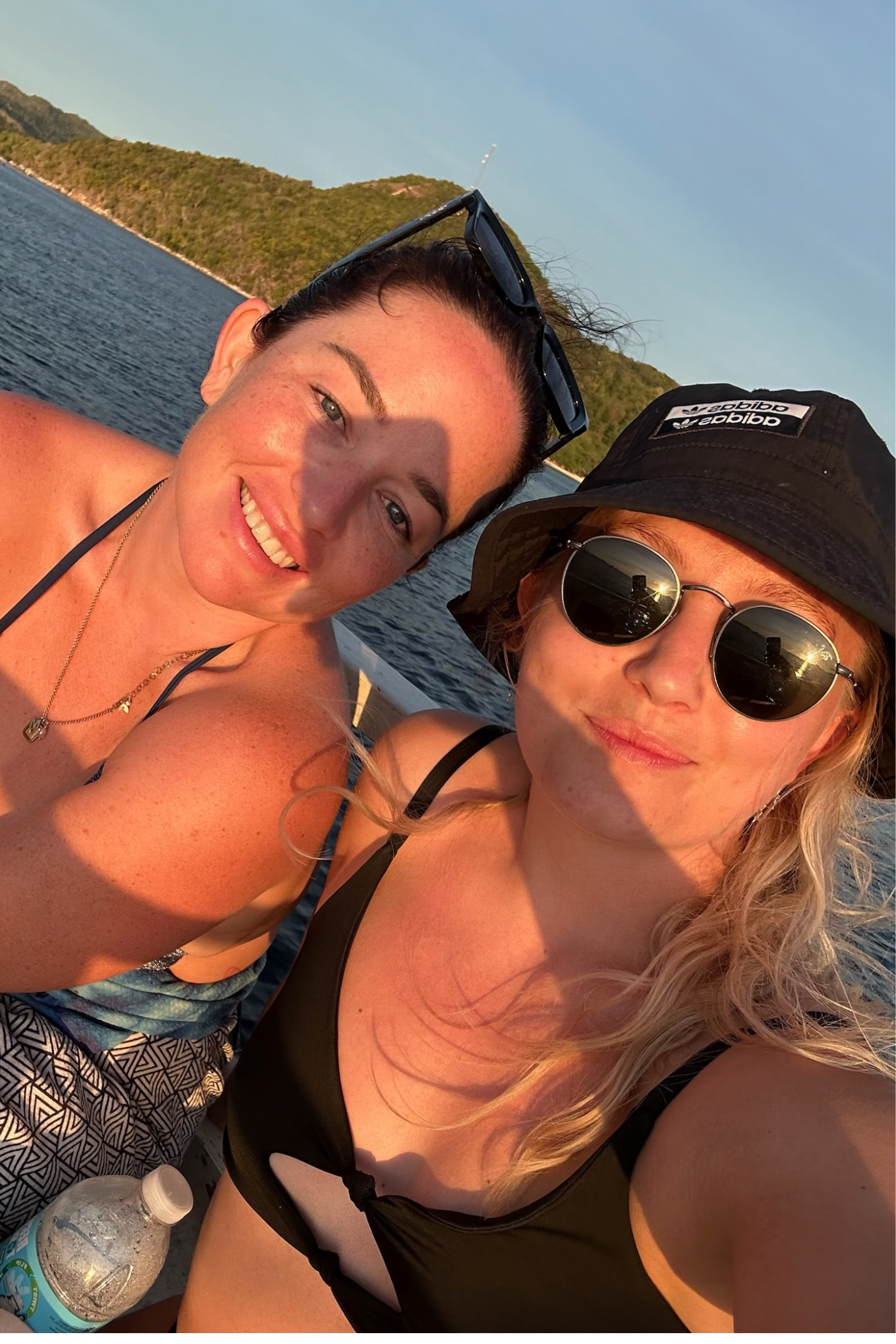 Selfie af to kvindelige rejsende med vand i baggrunden. 