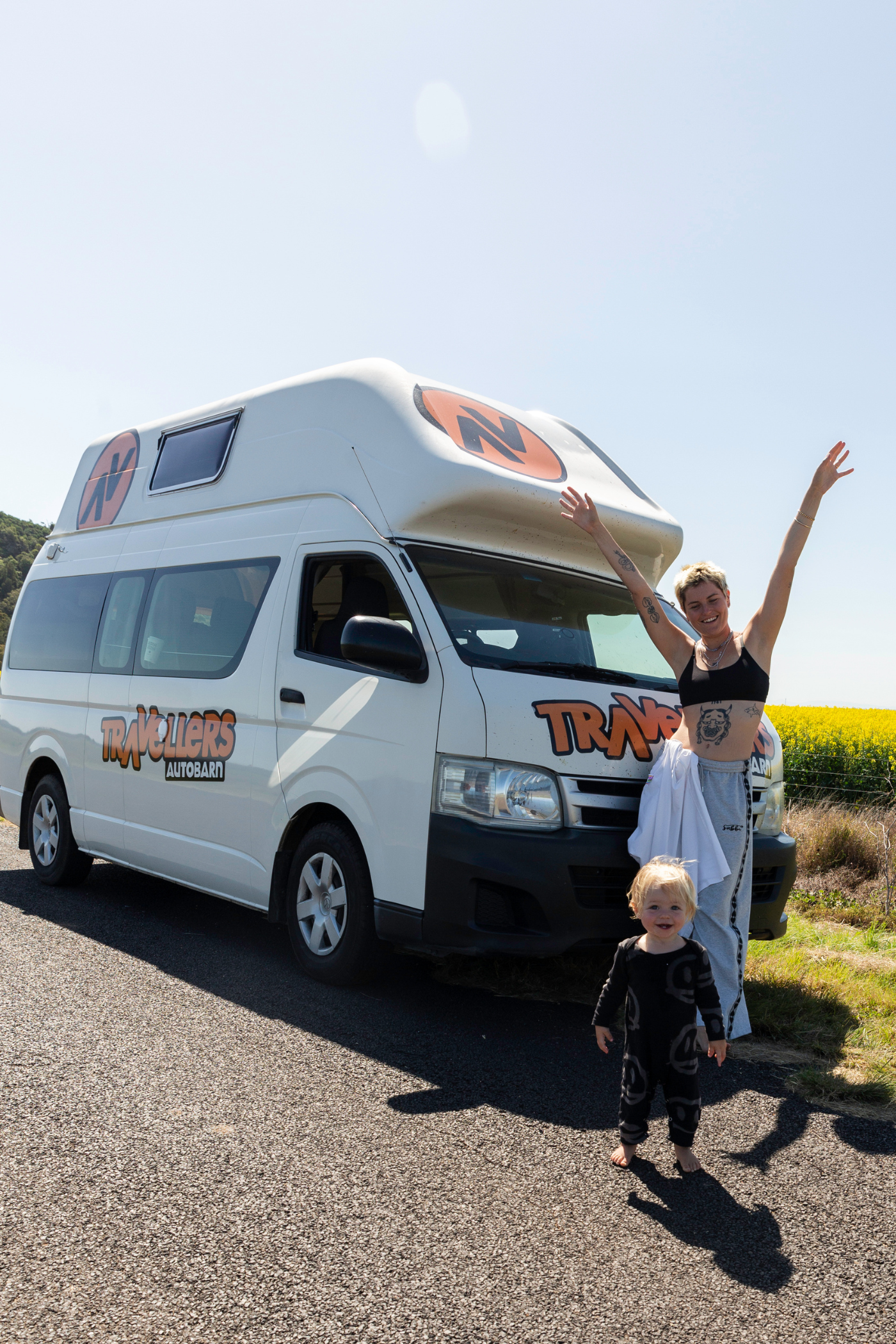 En kvinde og et lille barn foran en autocamper.