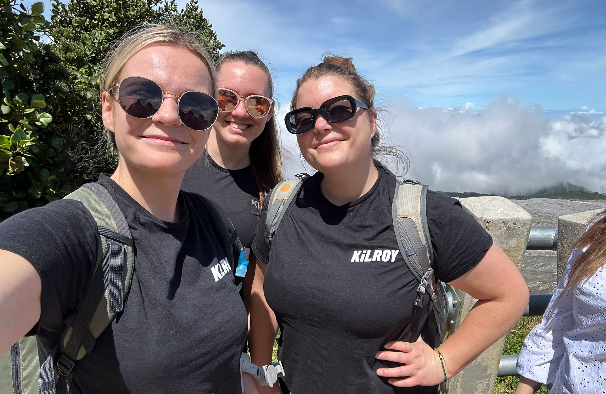 Selfie af tre unge kvinder iført Kilroy-t-shirts og solbriller. 