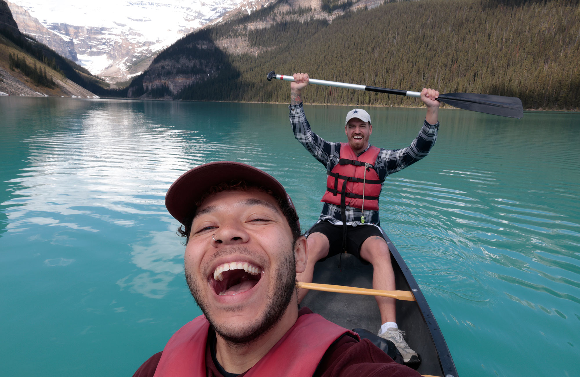 Selfie af to unge mænd, der sidder i en kano. De kigger ind i kameraet og smiler. 