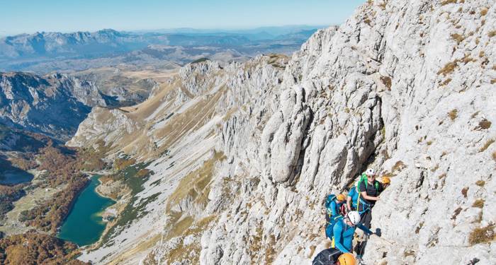 En re:discover-gruppe klatrer op på toppen af Bobotov Kuk i Montenegro