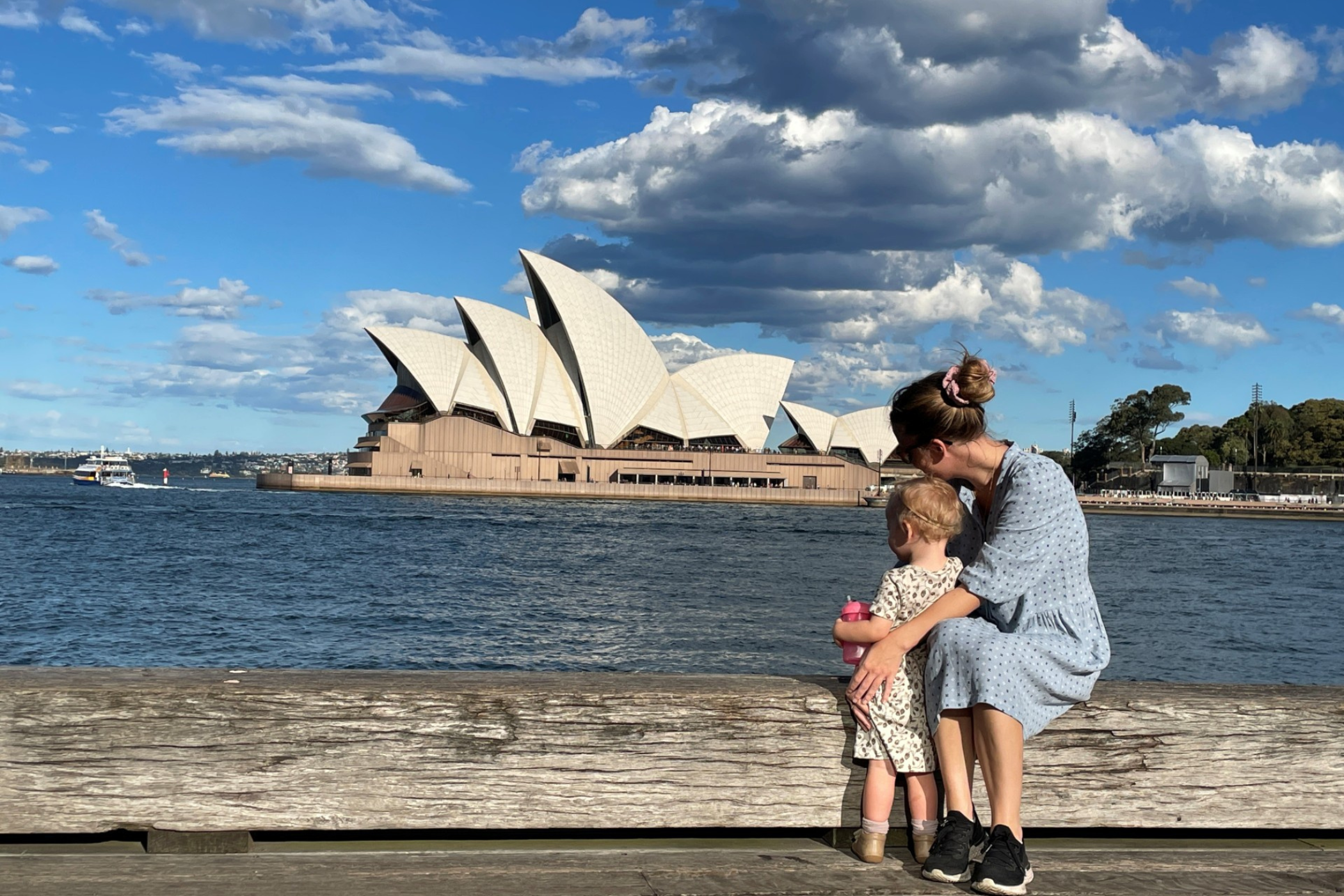 En mor med sit barn kigger på operahuset i Sydney.