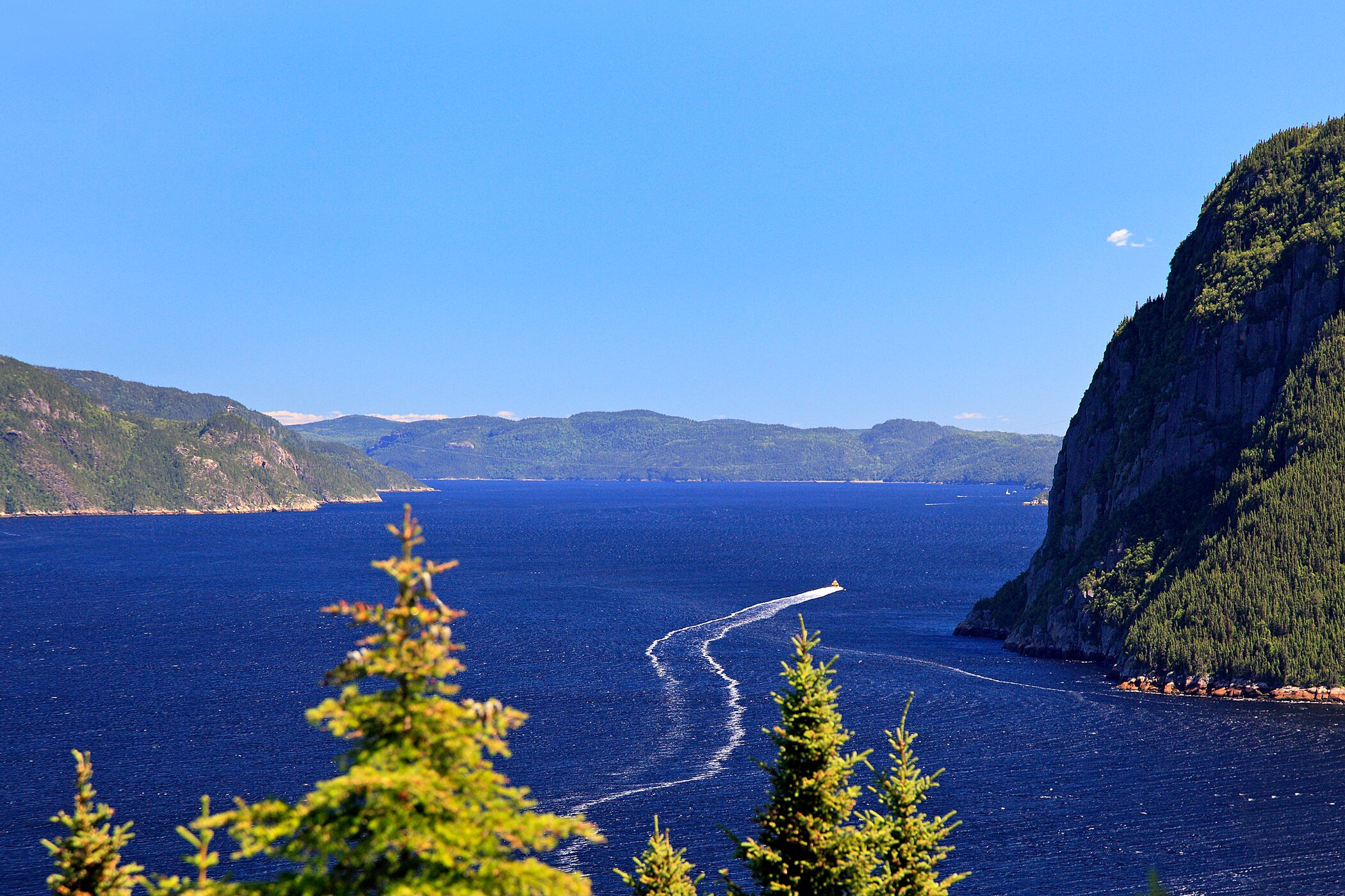 Udsigt over vandet i Canada. Der er bjerge i horisonten og i siderne af billedet. 